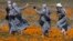 People walk in a field of California poppies and other wildflowers outside of the Antelope Valley California Poppy Reserve, after recent rains moved the region's second-driest winter on record up to its seventh-driest, near Lancaster, California, April 2,