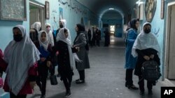 FILE - Afghan girls exit classrooms at Tajrobawai Girls High School, in Herat, Afghanistan, Nov. 25, 2021.