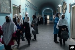 FILE - Afghan girls exit classrooms at Tajrobawai Girls High School, in Herat, Afghanistan, Nov. 25, 2021.