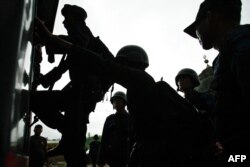 Polisi menaiki truk saat mencari tersangka anggota Jemaah Islamiyah di Aceh Besar, Provinsi Aceh pada 1 Maret 2010. (Foto: AFP)