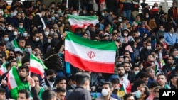 FILE - Iran supporters wave the national flag during the 2022 Qatar World Cup Asian Qualifiers football match between Iran and Lebanon, at the Imam Reza Stadium in the city of Mashhad, March 29, 2022.
