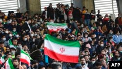 Iran supporters wave the national flag during the 2022 Qatar World Cup Asian Qualifiers football match between Iran and Lebanon, at the Imam Reza Stadium in the city of Mashhad, March 29, 2022.