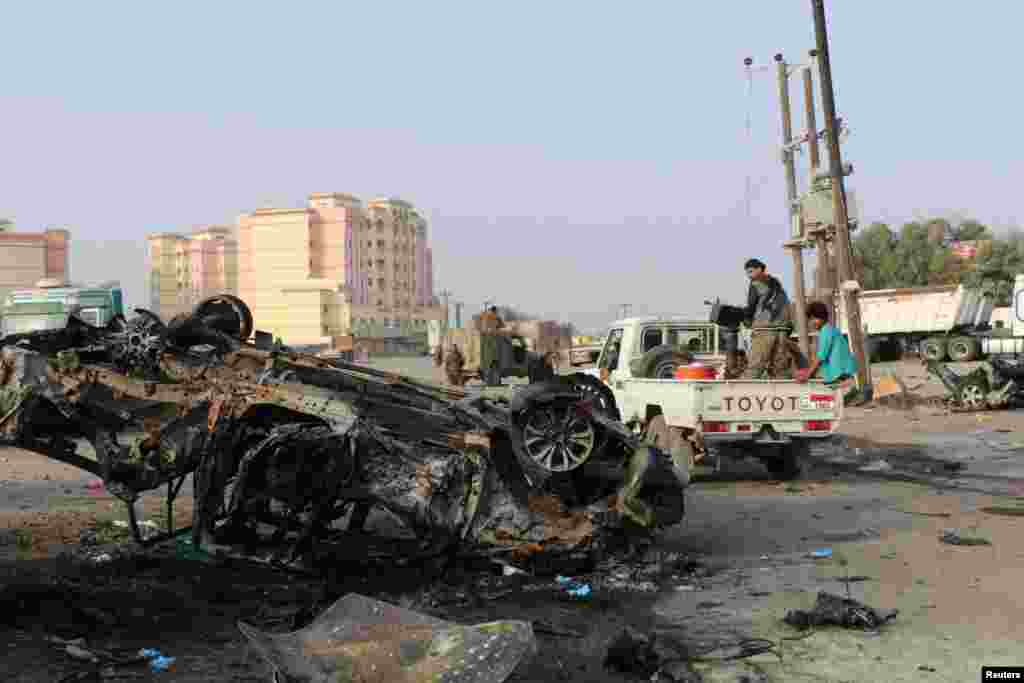 Soldiers look at the wreckage of a vehicle at the scene of a car bomb attack that killed a senior Yemeni military leader, Brigadier General Thabet Gawas, in the southern port city of Aden.