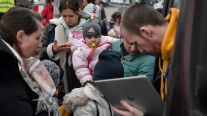 Seorang petugas bantuan kemanusiaan (kanan) memeriksa nama-nama pengungsi Ukraina di kamp sementara di Przemysl, Polandia sebelum dipindahkan ke Portugal (foto: dok). 