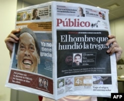 FILE - A person reads "Publico," a daily left-leaning national newspaper, in Madrid, Sept. 26, 2007.