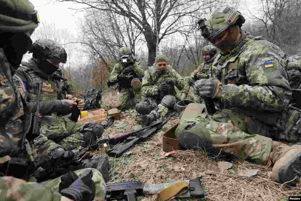 Miembros de las Fuerzas de Defensa Territorial de Ucrania cargan sus armas durante ejercicios tácticos, en medio de la invasión rusa de Ucrania, cerca de Leópolis, Ucrania.