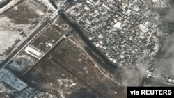 A satellite image shows a damaged bridge and craters in a field, amid Russia's ongoing invasion of Ukraine, in Irpin, Ukraine, March 8, 2022. Courtesy Maxar Technologies.