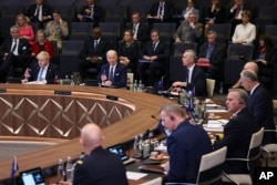 Britanski premijer Boris Johnson (levo), predsjednik SAD Joe Biden slušaju izlaganje generalnog sekretara NATO Jensa Stoltenberga, tokom sastanka Sjevernoatlantskog savjeta, u sklopu samita NATO, čija je tema ruska invazija na Ukrajinu, u sjedištu Alijanse, u Briselu, 24. marta 2022.