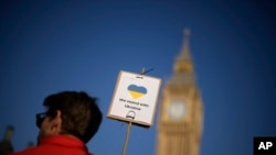 На фото: Парламентська площа, навпроти будівлі парламенту, Лондон, вівторок, 8 березня 2022 р. Текст на плакаті: "Ми підтримуємо Україну"