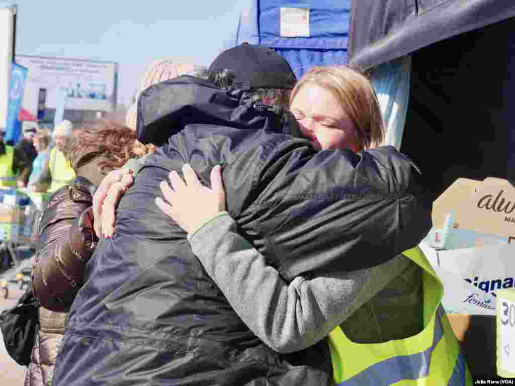 Visiblemente emocionadas, voluntarias se abrazan tras una jornada de trabajo.