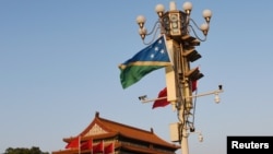 FILE - National flags of the Solomon Islands and China flutter at Tiananmen Square in Beijing, China, Oct. 7, 2019.