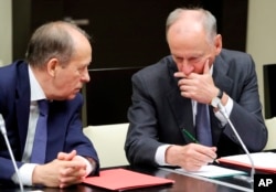 FILE - Alexander Bortnikov, head of Russia's Federal Security Service, left, speaks to Russian Security Council Secretary Nikolai Patrushev at a Security Council meeting with Russian President Vladimir Putin in the Kremlin, in Moscow, Russia, Aug. 5, 2019.