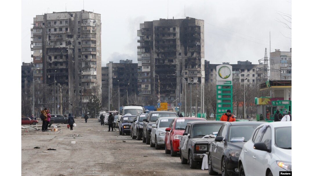 A view shows a line of cars near apartment buildings destroyed during in Russia's invasion of Ukraine, as evacuees leave the besieged port city of Mariupol, Ukraine, March 17, 2022.