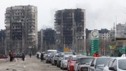 A view shows a line of cars near blocks of flats destroyed during the Ukraine-Russia conflict, as evacuees leave the besieged port city of Mariupol, Ukraine, March 17, 2022.