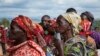 FILE - Women hold their identity cards as they queue to cast their votes in the presidential election, in Giheta, Gitega province, Burundi Wednesday, May 20, 2020. (AP Photo/Berthier Mugiraneza)