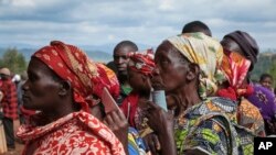 FILE - Women hold their identity cards as they queue to cast their votes in the presidential election, in Giheta, Gitega province, Burundi Wednesday, May 20, 2020. (AP Photo/Berthier Mugiraneza)