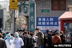 Warga berbaris di luar tempat pengujian asam nukleat sebuah rumah sakit, menyusul kasus COVID-19, di Shanghai, China 11 Maret 2022. (Foto: China Daily via REUTERS)