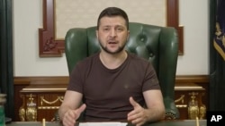 En esta imagen de un video proporcionado por la Oficina de Prensa Presidencial de Ucrania, el presidente ucraniano Volodymyr Zelenskyy habla desde Kiev, Ucrania, la madrugada del domingo 20 de marzo de 2022. (Oficina de Prensa Presidencial de Ucrania vía AP)