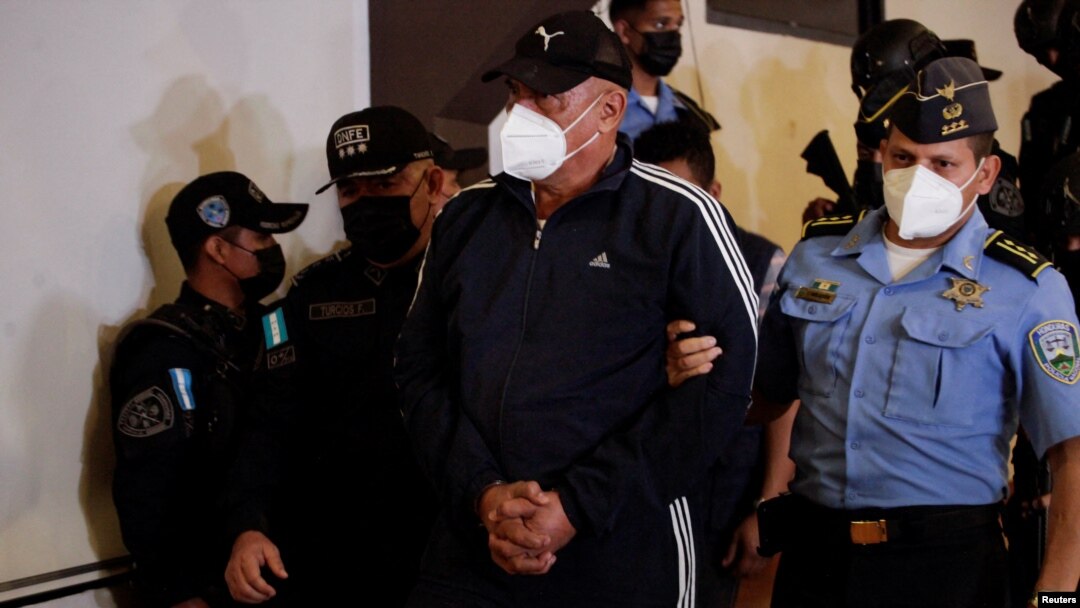 Agentes policiales escoltan al exjefe policial Juan Carlos "El Tigre" Bonilla, buscado por EE.UU. por narcotráfico, para presentarlo ante los medios de comunicación en una base policial tras su detención tras varios meses prófugo, en Tegucigalpa. Honduras 9 de marzo de 2022.