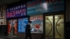 FILE - A man walks past a store advertising cargo shipping to Russia and other countries, along a street in Beijing, March 4, 2022. 