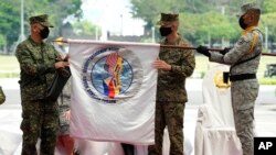 Philippine and US officers unfurl the 'Balikatan' or 'Shoulder to Shoulder' flag during opening ceremonies of military exercises Camp Aguinaldo, Quezon City, Philippines, March 28, 2022.