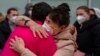 Ucranianos desplazados se abrazan después de llegar en autobús al Hospital Zendal en Madrid, España, el miércoles 16 de marzo de 2022.