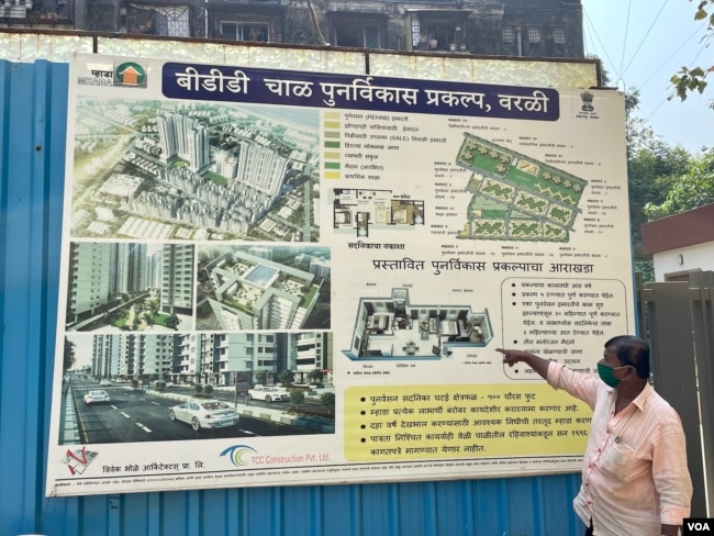 Bhagwan Sawant, a resident of BDD Chawls, looks at posted plans for the BBD Chawl development, including new 45 square-meter foot homes to be given to occupants to replace their smaller homes. (Anjana Pasricha/VOA)