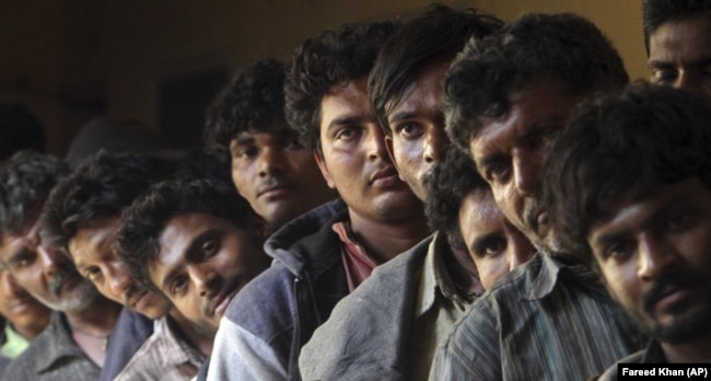 Arrested Indian fishermen stand in line while waiting for registration at a police station in Karachi, Pakistan, Sunday, Nov. 20, 2016. Pakistan's Maritime Security Agency-MSA has arrested 43 Indian fishermen along with their eight boats for violating Pakistani territorial waters limit while fishing, a police official said. (AP Photo/Fareed Khan)