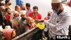 লাইনে দাঁড়িয়ে টিসিবি'র ট্রাক থেকে ভোজ্য তেল ক্রয় করছে মানুষ। 