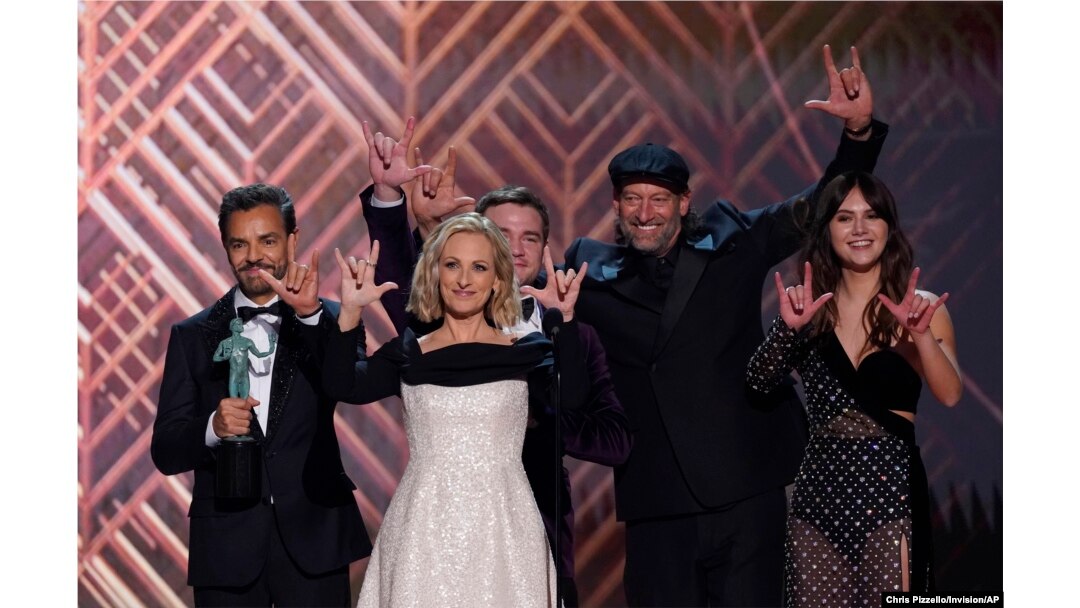 The cast of "Coda" accepts the award for outstanding performance by a cast in a motion picture and signs "I love you" at the 28th annual Screen Actors Guild Awards at the Barker Hangar, Feb. 27, 2022, in Santa Monica, California.