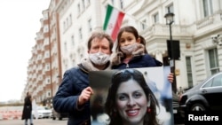 FILE - Richard Ratcliffe, husband of British-Iranian aid worker Nazanin Zaghari-Ratcliffe, and their daughter Gabriella protest outside the Iranian Embassy in London, March 8, 2021.