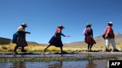 FILE - Aymara Indigenous people walk along the Silala springs, in Potosi department, southwestern Bolivia, 4 kilomters away from the border with Chile, on March 29, 2016.. 