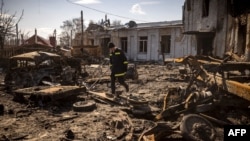 Un pompier ukrainien marche dans les décombres de la ville de Trostianets, dans le nord-est du pays, le 29 mars 2022. (AFP)