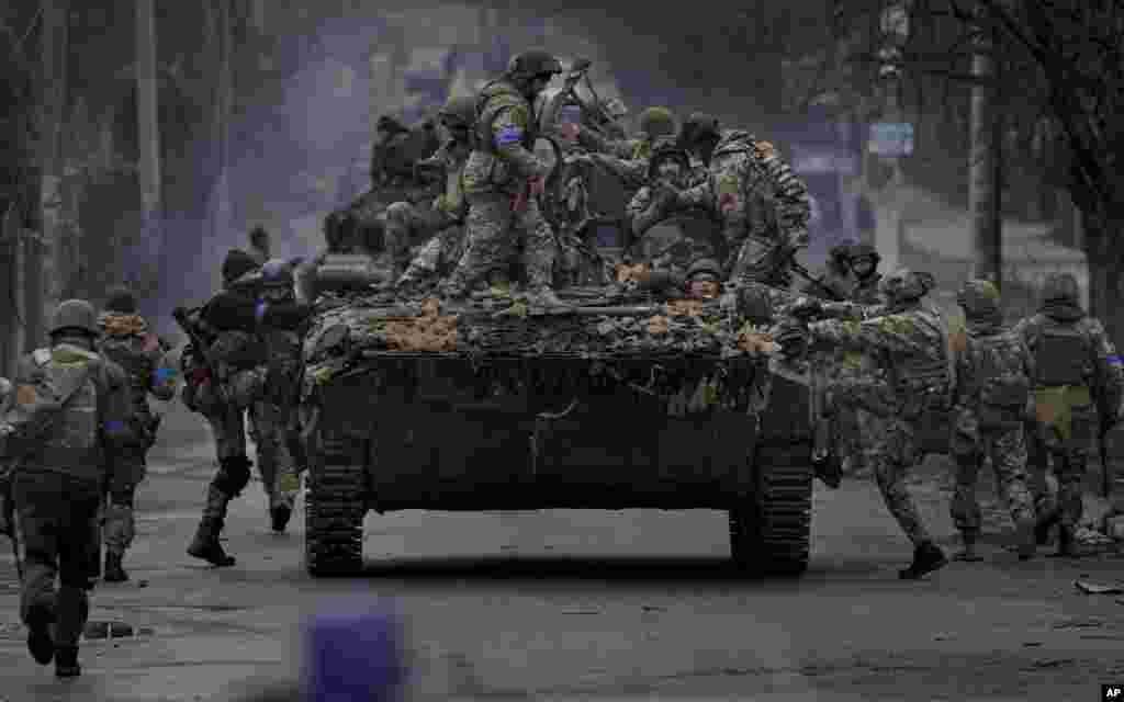 Ukrainian servicemen climb on an armor vehicle outside Kyiv, Ukraine, April 2, 2022.