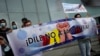 Personas que dicen que sus familiares son víctimas de violaciones de derechos humanos sostienen un cartel que dice en español "¡Di no a la tortura!" frente a la sede del Programa de las Naciones Unidas para el Desarrollo (PNUD) en Caracas, el 29 de octubre de 2021.