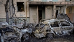 在被俄罗斯轰炸损坏的基辅一座居民楼内,一名妇女在清扫她的厨房内的瓦砾碎片。(2022年3月21日)