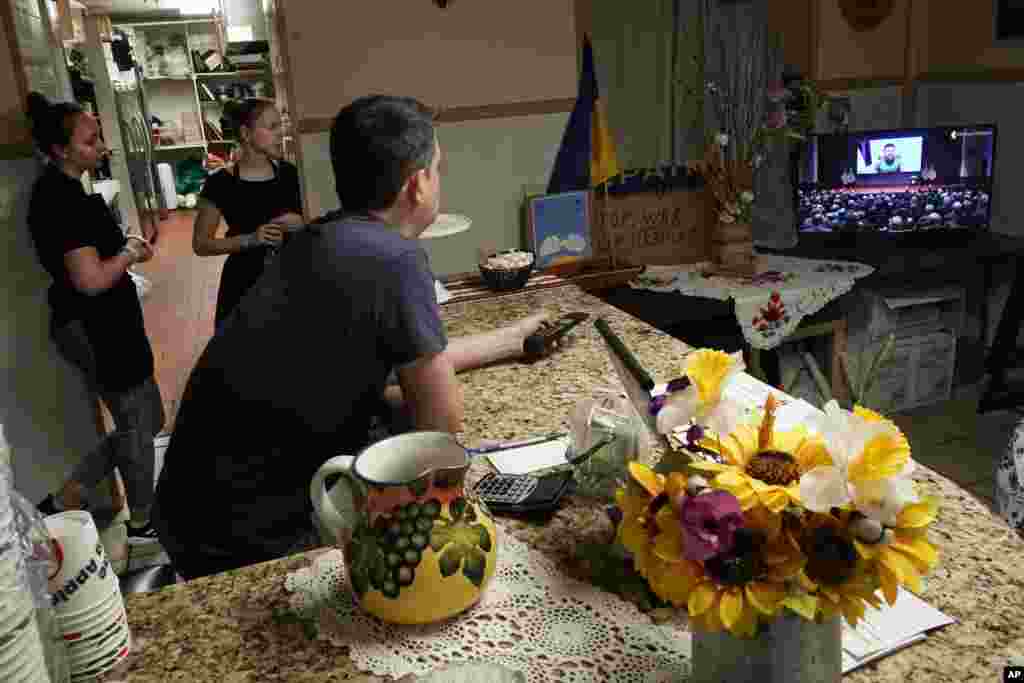 Dmytro Kovalenko (foreground), manager of Ukrainian restaurant Streecha in New York, and&nbsp; employees watch Ukrainian President Volodymyr Zelenskyy deliver a virtual address to the U.S. Congress.