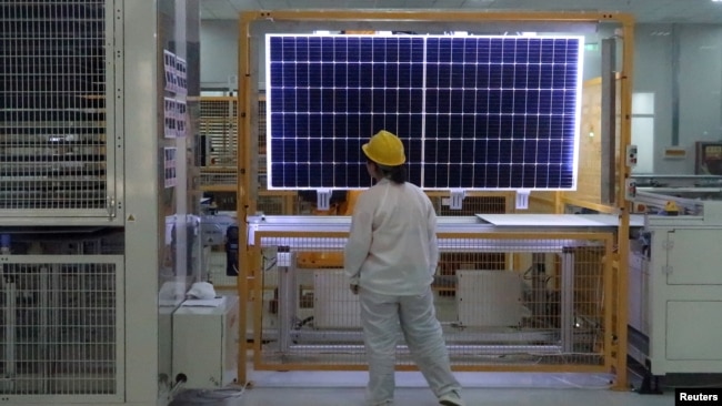 FILE - A worker conducts a quality check of a solar module at a factory in Xian, China, on Dec. 10, 2019. The European Union said on Jan. 24, 2024, that it wants to avoid over-reliance on China, which dominates in green technology production and other industries.