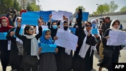 Afghan women and girls take part in a protest in front of the Ministry of Education in Kabul, Afghanistan, March 26, 2022, demanding that secondary schools be reopened for girls. 
