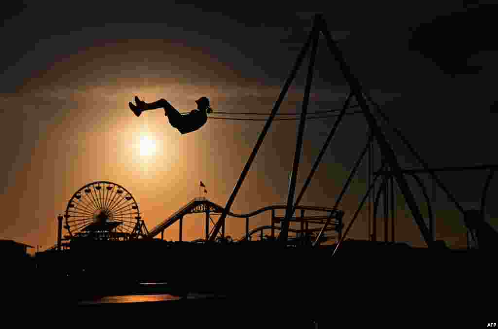 A person rides a swing at Santa Monica Beach, California, March 30, 2022.