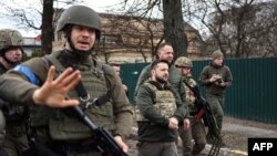 Ukrainian President Volodymyr Zelenskyy (center) walks in the town of Bucha, just northwest of Ukraine's capital, Kyiv, on April 4, 2022.