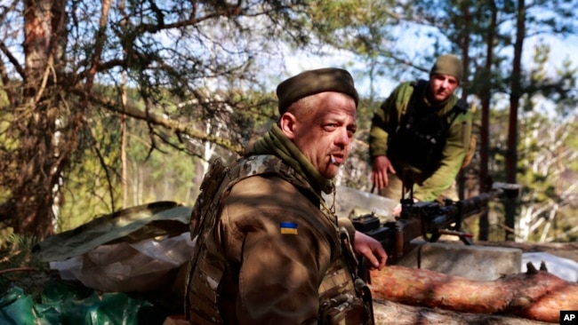 Ukrainian servicemen guard their position near Brovary, north of Kyiv, March 17, 2022.