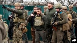 Presiden Ukraina Volodymyr Zelenskyy (tengah) meninjau lokasi pertempuran di wilayah Bucha, yang beredekatan dengan ibu kota Ukraina, Kyiv, pada 4 April 2022. (Foto: AP/Efrem Lukatsky)
