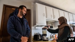 Afghani evacuees Israr, 26, and his wife Sayeda, 23, make a morning smoothie of fruit, nuts and milk, an American concept her and her husband Israr have been trying for a few weeks instead of tea, at their new apartment in Charlestown, Massachusetts on February 21, 2022.