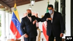 FILE - Handout picture released by Venezuelan Presidency showing Venezuela's President Nicolas Maduro (R) bumping elbows with the Foreign Minister of the Islamic Republic of Iran, Javad Zarif (L) at Miraflores Palace in Caracas, on November 5, 2020.