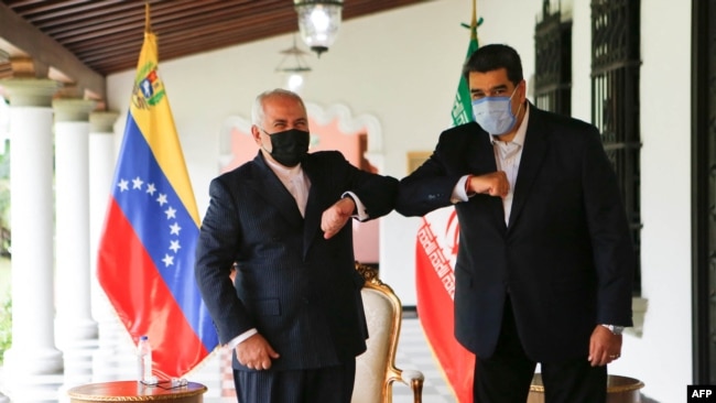 FILE - Handout picture released by Venezuelan Presidency showing Venezuela's President Nicolas Maduro (R) bumping elbows with the Foreign Minister of the Islamic Republic of Iran, Javad Zarif (L) at Miraflores Palace in Caracas, on November 5, 2020.