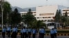 Police officers cross a road, with the Pakistan's parliament building in the background, in Islamabad, Pakistan, March 28, 2022.