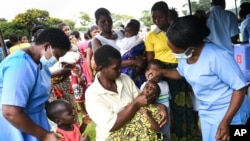 FILE: A child receives a polio vaccine during the Malawi Polio Vaccination Campaign Launch in Lilongwe Malawi, Sunday March 20, 2022. 