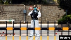 香港爆发新冠病毒期间，一名身穿个人防护装备的中国解放军士兵在香港的解放军总部入口守卫。（2022年3月15日） 