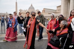 President of the Metis community, Cassidy Caron, at center in black outfit, and other delegates arrive to speak to the media in St. Peter's Square after their meeting with Pope Francis at The Vatican, March 28, 2022.